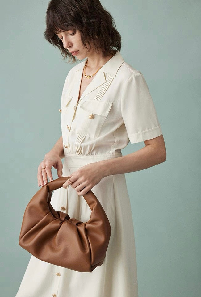 Front view of cream cotton shirt dress with brown buttons