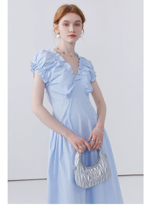 Feminine pastel dress styled with sandals and silver bag