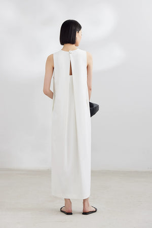 White sleeveless maxi dress with black clutch