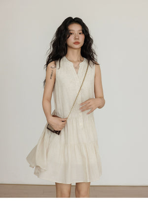 Sleeveless beige linen vest dress styled with black boots