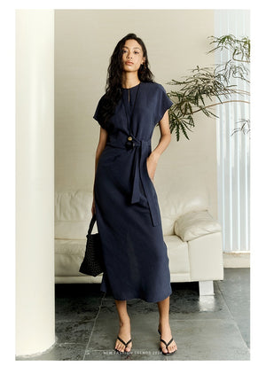 Model wearing belted white linen dress with relaxed fit
