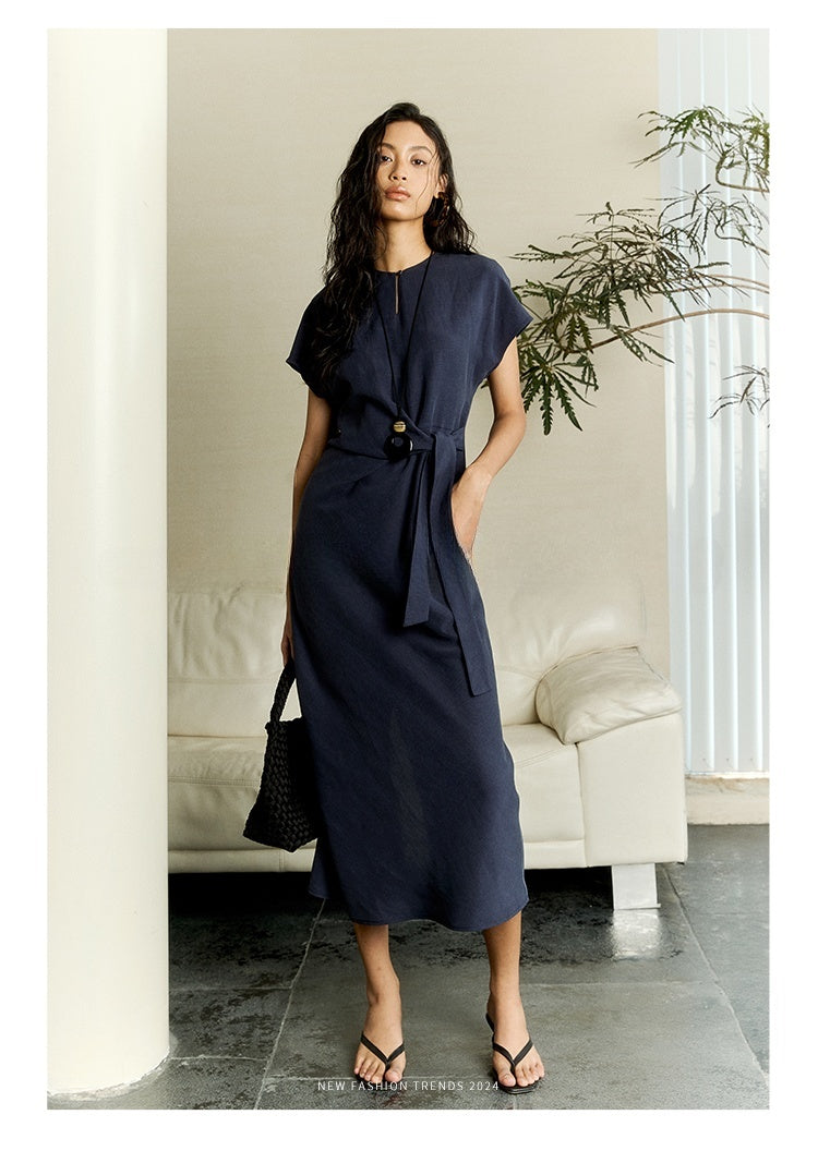 Model wearing belted white linen dress with relaxed fit