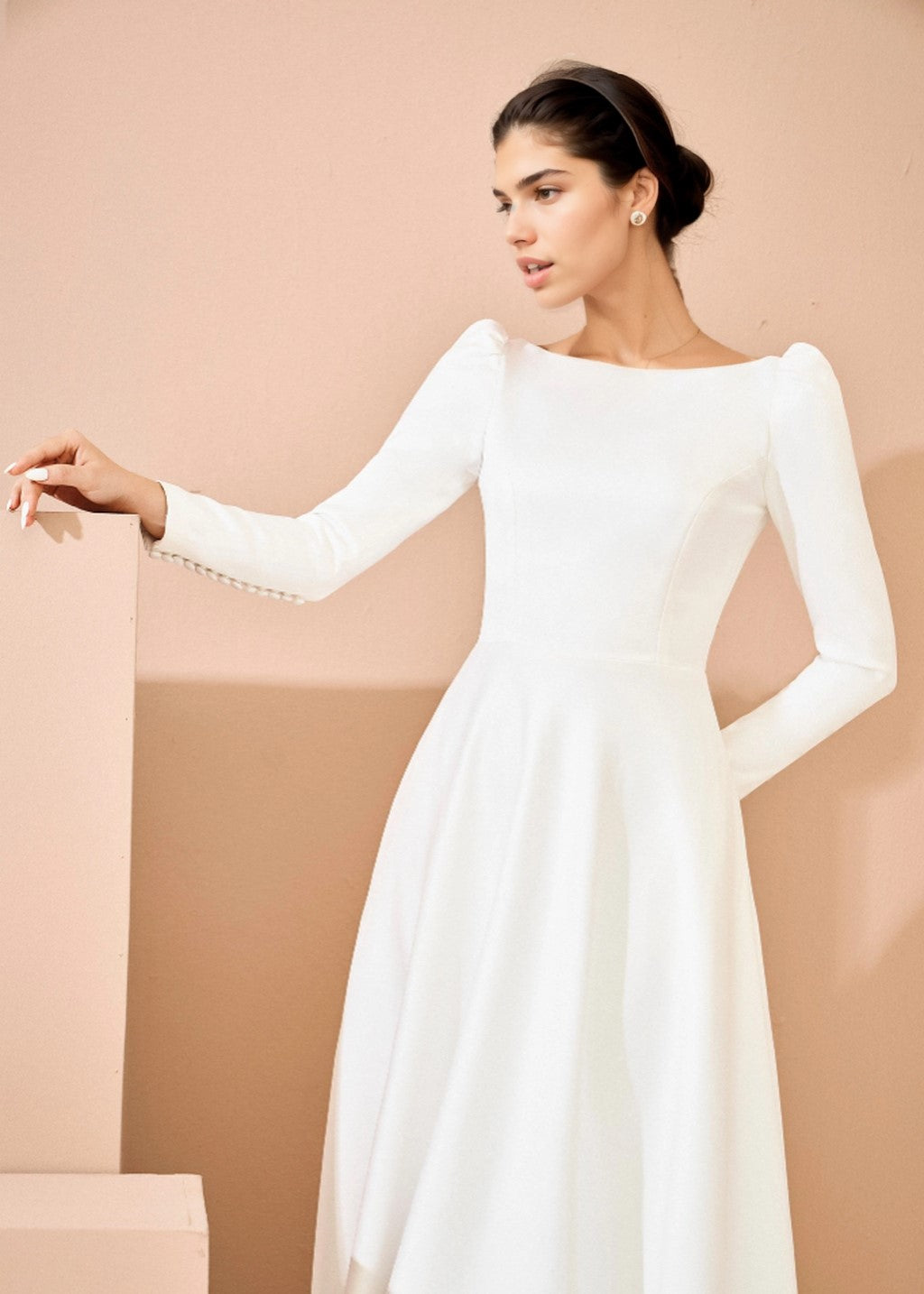 The wedding dress has a deep V-back and long sleeves.