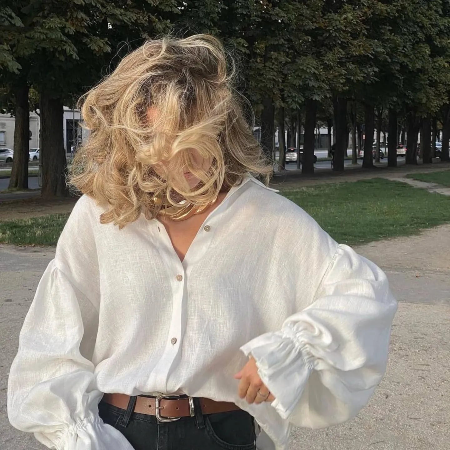 Woman wearing oversized white linen shirt outdoors