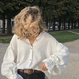 Woman wearing oversized white linen shirt outdoors