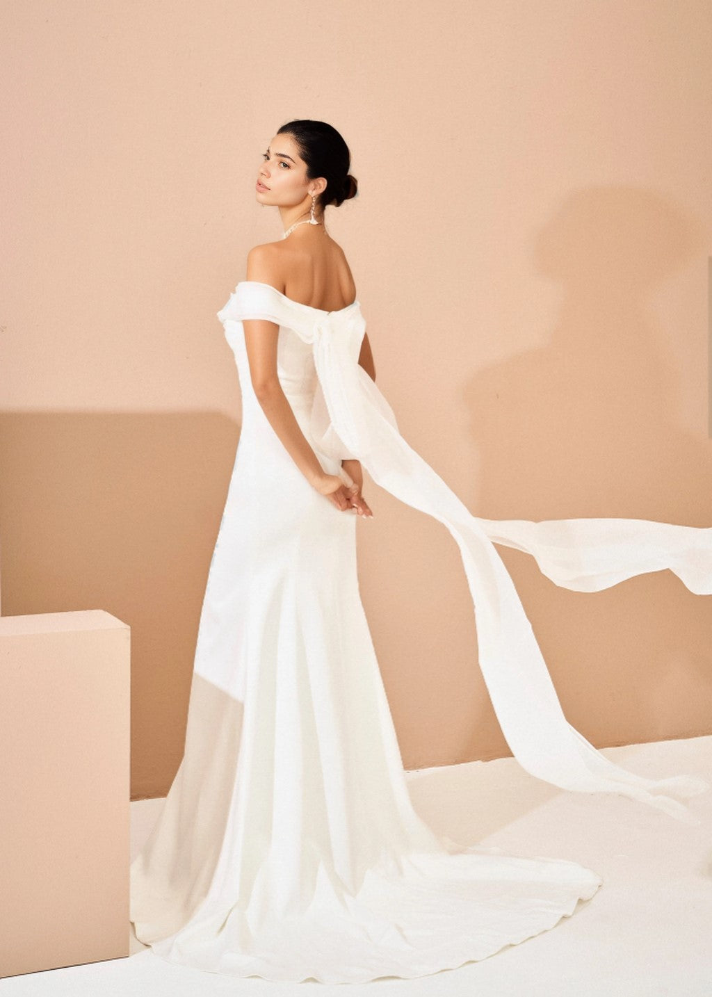 The off-shoulder fishtail wedding dress has a slit at the tail.