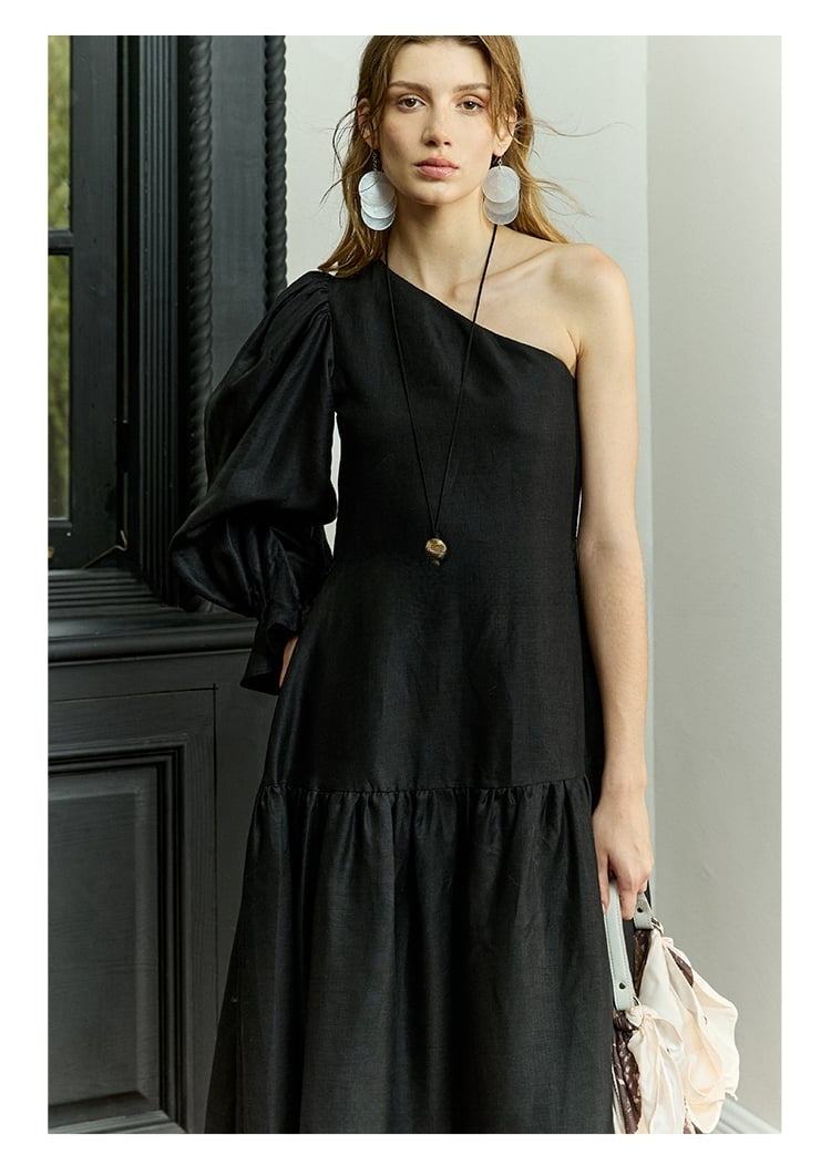 Model in one-shoulder black linen dress with puff sleeve
