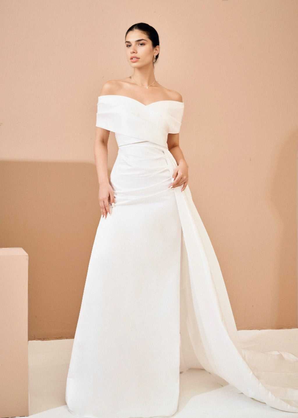 The off-shoulder wedding dress comes with a train.