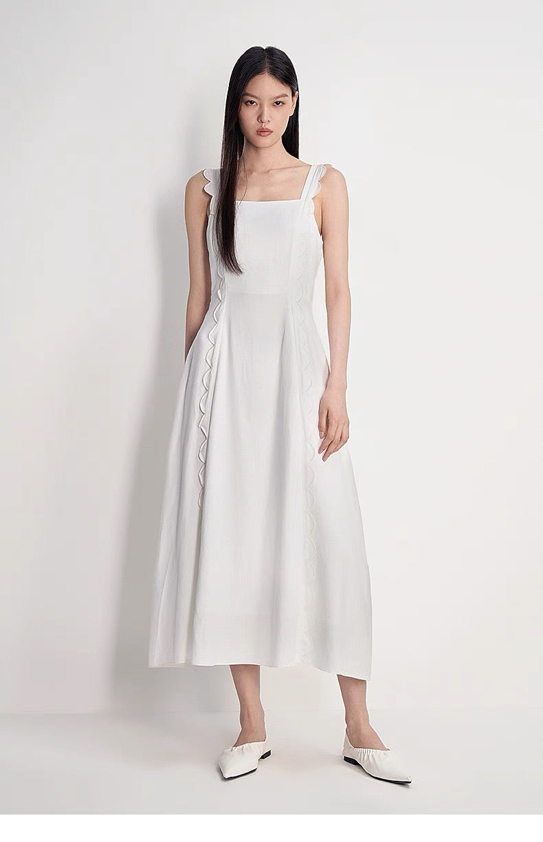 Close-up of scalloped strap and square neckline on white dress