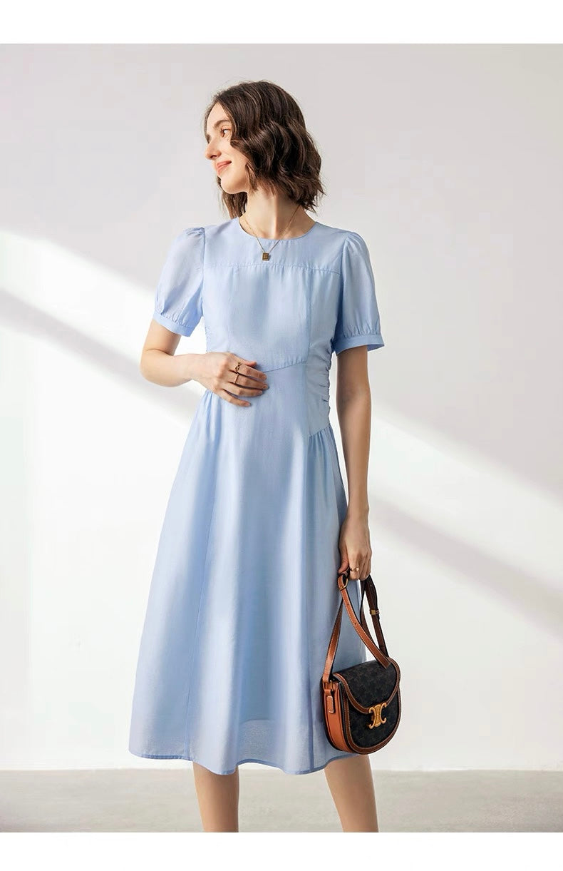 Woman in light blue acetate puff sleeve dress facing front