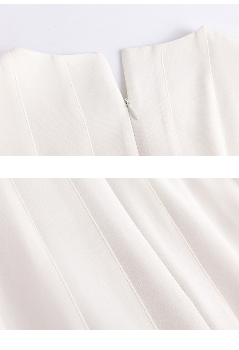 Detail of stitched pleats on ivory cotton-blend dress