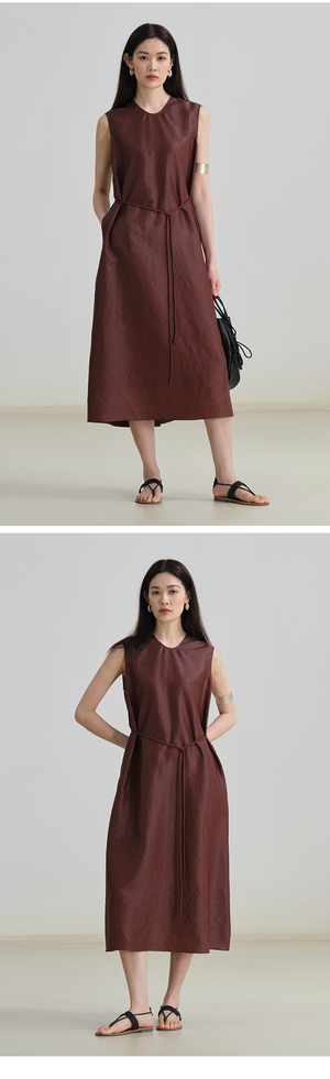 Model wearing sleeveless linen midi dress with tie waist and round neckline