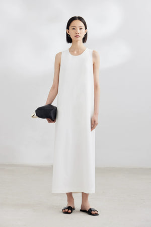 White sleeveless maxi dress with black clutch