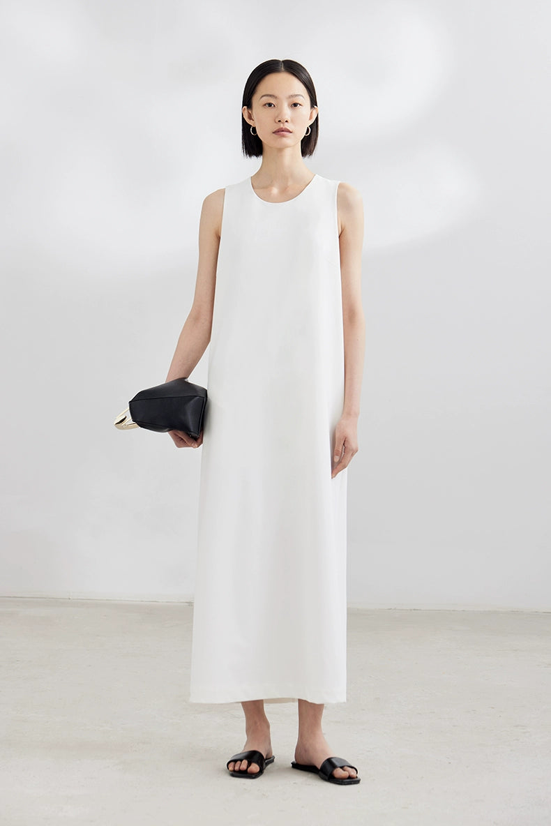 White sleeveless maxi dress with black clutch