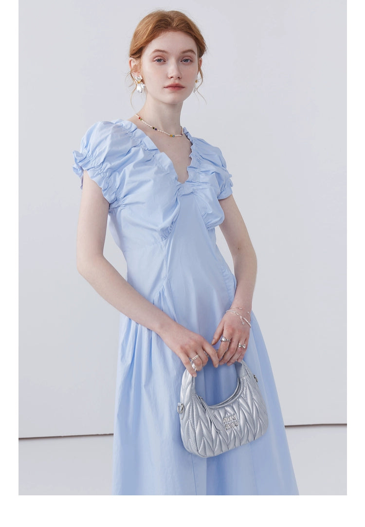 Feminine pastel dress styled with sandals and silver bag