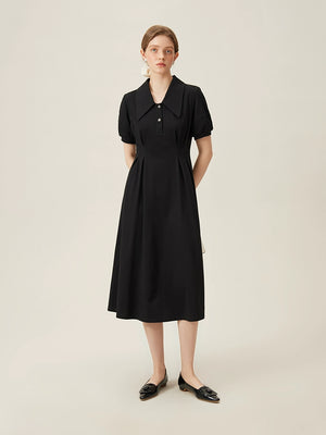 Model wearing black linen dress with puff sleeves and wide collar holding-two-tone 
