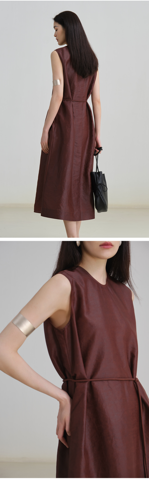 Woman walking on the beach in sleeveless midi-length linen dress with pockets