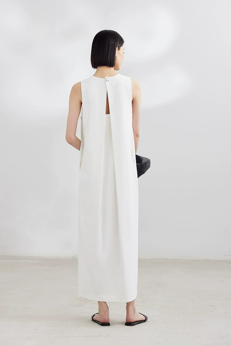 White sleeveless maxi dress with black clutch