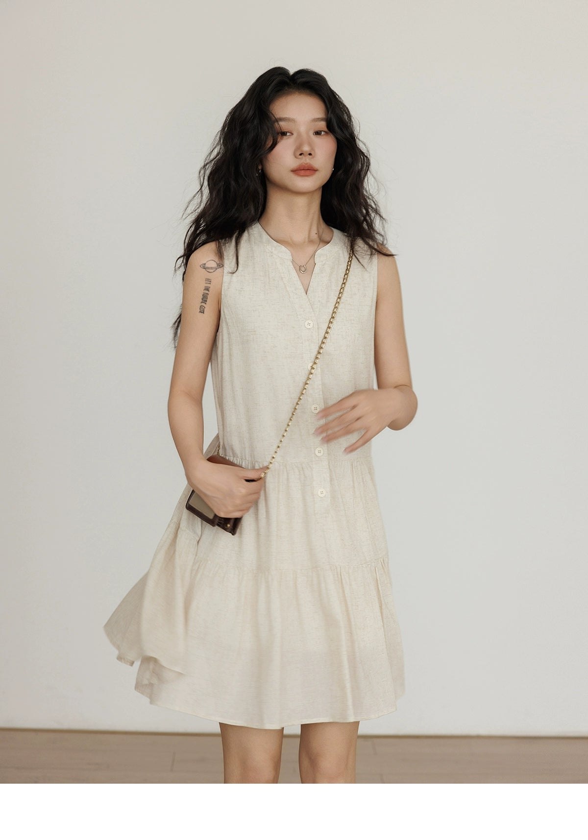 Sleeveless beige linen vest dress styled with black boots
