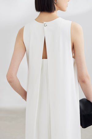 White sleeveless maxi dress with black clutch