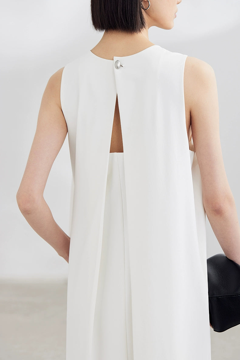 White sleeveless maxi dress with black clutch
