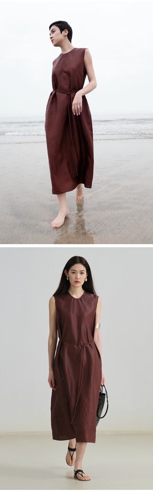 Model wearing sleeveless linen midi dress with tie waist and round neckline
