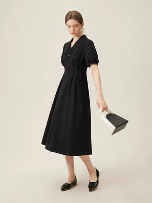 Back view of midi-length linen dress in black with puff sleeves