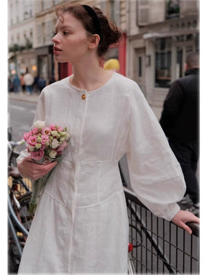 White linen A-line dress with lantern sleeves and cinched waist