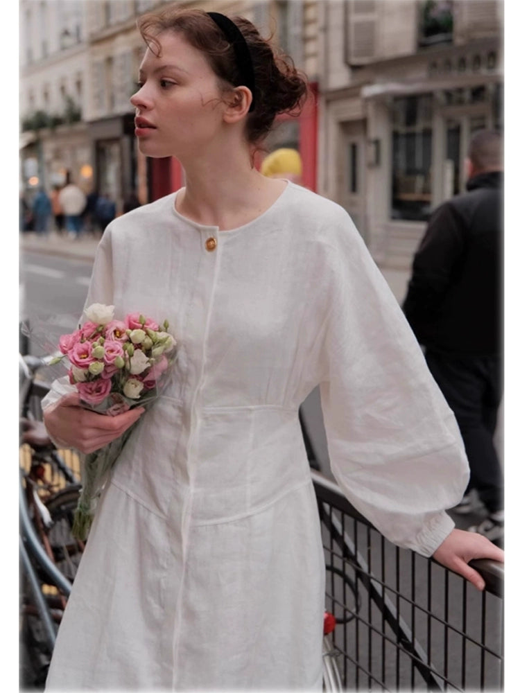 White linen A-line dress with lantern sleeves and cinched waist