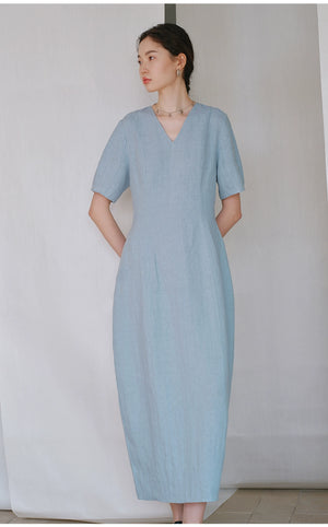 Side profile of woman wearing minimalist linen V-neck dress