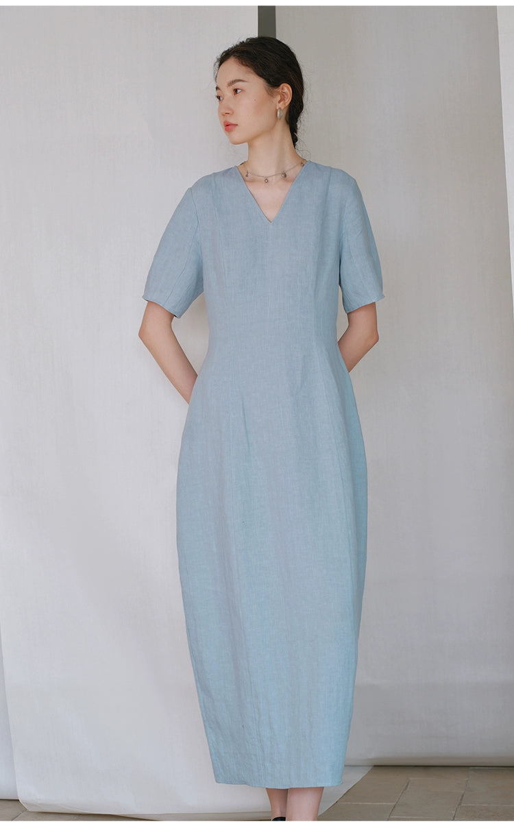  Side profile of woman wearing minimalist linen V-neck dress