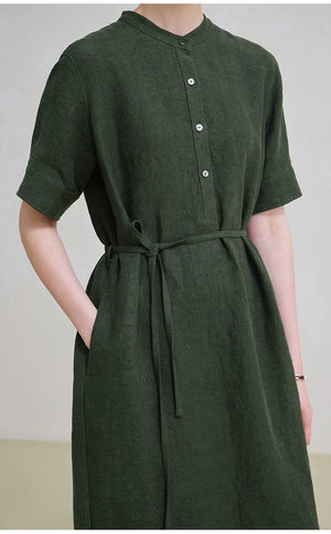 Side angle of model holding woven tote while wearing linen midi dress