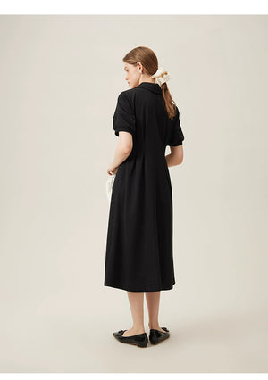 Model wearing black linen dress with puff sleeves and wide collar holding-two-tone 