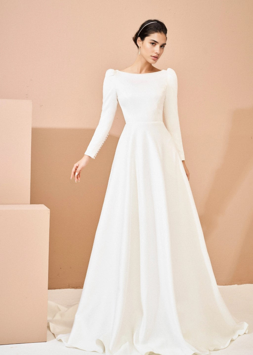 The wedding dress has a deep V-back and long sleeves.