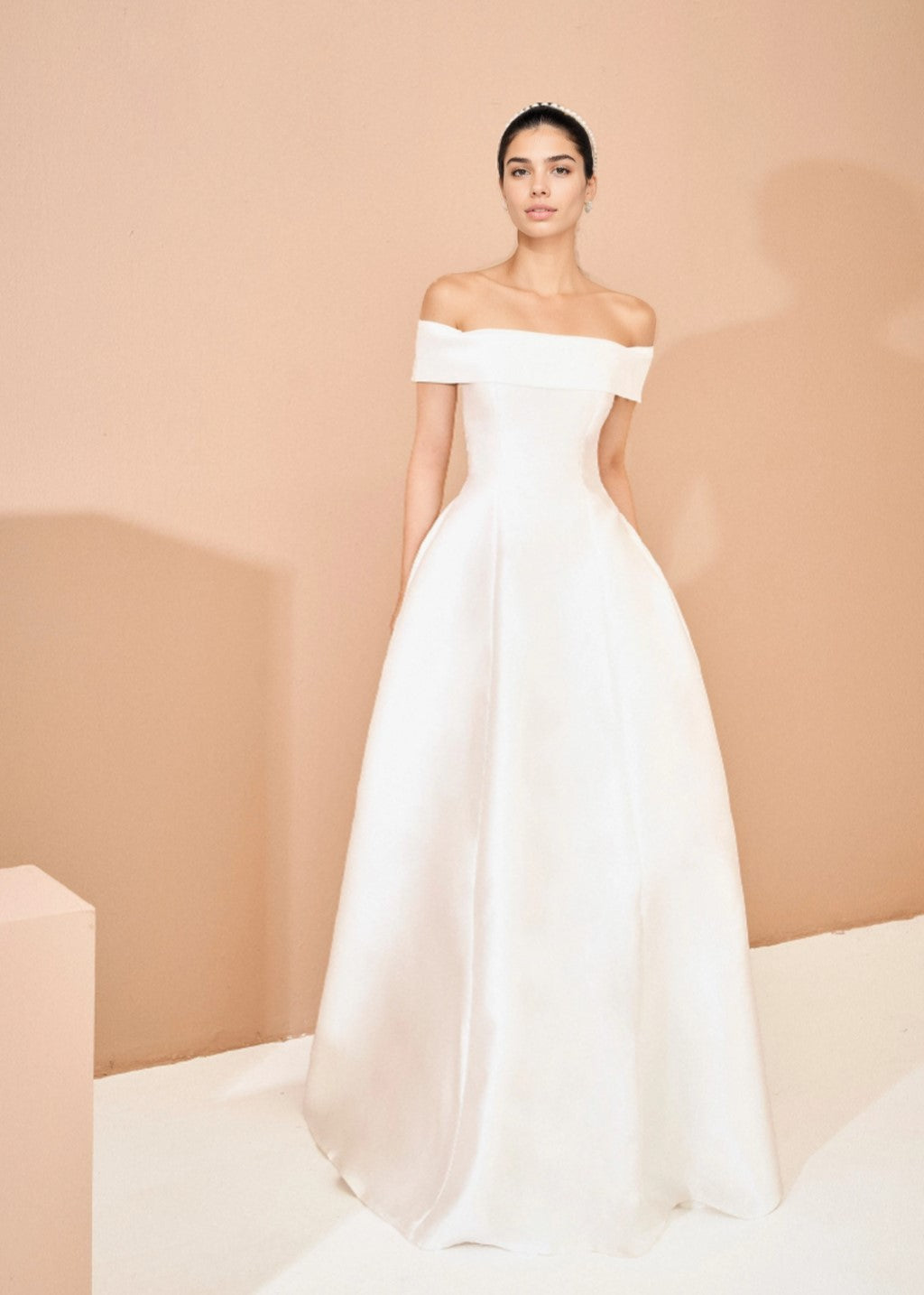 The off-shoulder princess-style wedding gown has a flared silhouette.